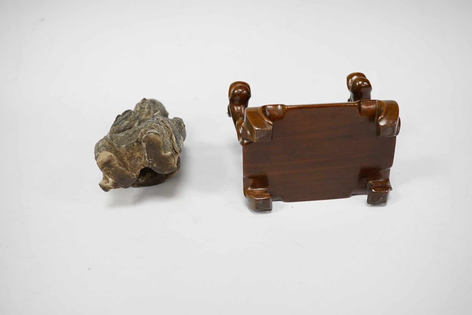 A Chinese grey pottery seated figure of a God, possibly Ming dynasty, seated on a later wood throne (with receipt of purchase from C C Tih Gallery, Hong Kong, 1968), 15cm high. Condition - fair